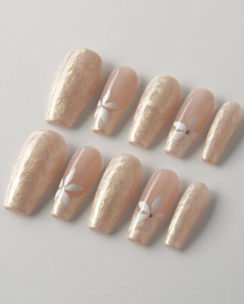 Spiral Twist nails with soft pearl nude base, silk texture, and glossy daisy accents