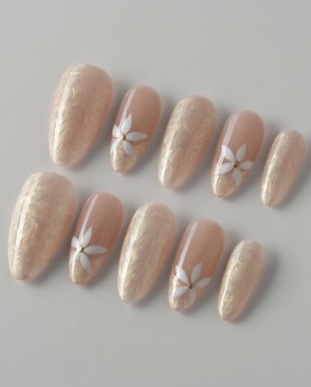 Spiral Twist press-on nails with pearly nude silk effect and delicate daisy nail details