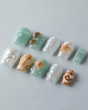 Mauritius Escape vacation nails with glossy mint shimmer, shell texture, and pearl drops