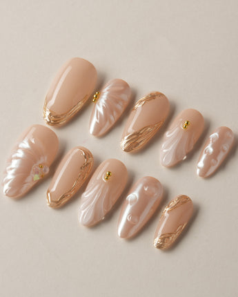 Venus hand-painted shell press-on nails with soft nude shimmer and gold accents