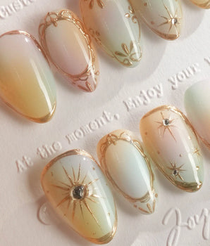 Pastel Relic handmade press-on nails featuring champagne gradient gold line starbursts