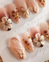 Close-up of Caramel Cream nails with caramel 3D flowers and fine gold wire accents