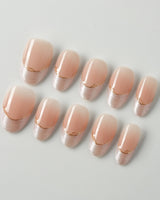 Your Glow press-on nails with nude cat-eye French tips, glossy gel shine, and gold wire detail