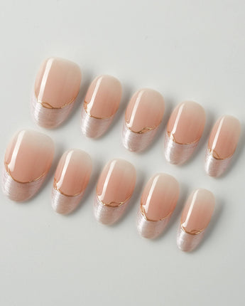 Your Glow press-on nails with nude cat-eye French tips, glossy gel shine, and gold wire detail