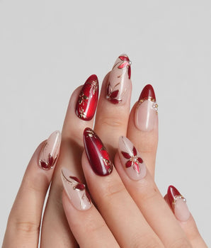 Crimson Petals press-on nails with deep red French tips and gold outlined floral accents