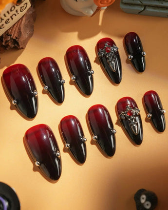 The Curse handmade press-on nails featuring red to black gradient glossy chrome studs gothic cross charm