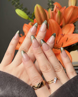 Silk Green nail design with dark green cat-eye effect, nude base, and glossy gel finish