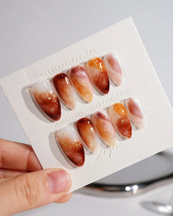 Onyx Shine nail close-up with amber marble pattern and glossy onyx-like depth