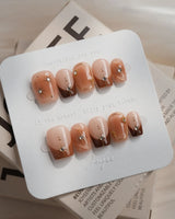 Fall Makeup nail design with brown ombre, metallic star linework, and sparkling gems