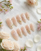 First Vow nail art close-up showing Gentle Milk Tea Nude, Hand-painted White Florals & Pearl Accents. details
