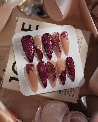 Velvet Flow press-on nails with metallic outlined butterfly wings and glossy berry red gel