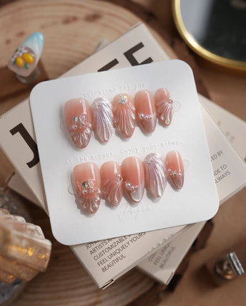 Glow Shore pearly nude press-on nails with seashell and starfish summer accents