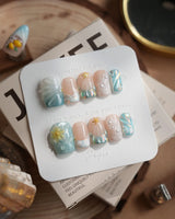 Yasawa Blue tropical tidepool nails with pearl strands, shell swirls, and gold starfish