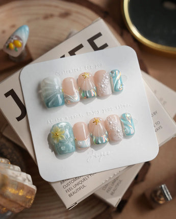 Yasawa Blue tropical tidepool nails with pearl strands, shell swirls, and gold starfish