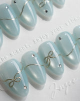 Soda Bubble nail art close-up showing Fresh Icy Blue, Simple Gold Wire Bows & Rhinestones. details