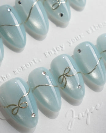 Soda Bubble nail art close-up showing Fresh Icy Blue, Simple Gold Wire Bows & Rhinestones. details