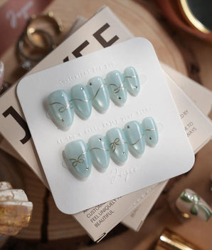 Soda Bubble handmade press-on nails featuring Fresh Icy Blue, Simple Gold Wire Bows & Rhinestones.
