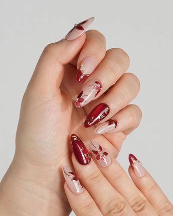 Crimson Petals press-on nails with deep red tips, nude base and gold floral detailing