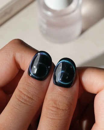 Absinthe press on nails in black with an emerald green cat eye halo and small silver star accents - image 4