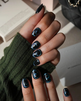 Absinthe press on nails in black with an emerald green cat eye halo and small silver star accents - image 5