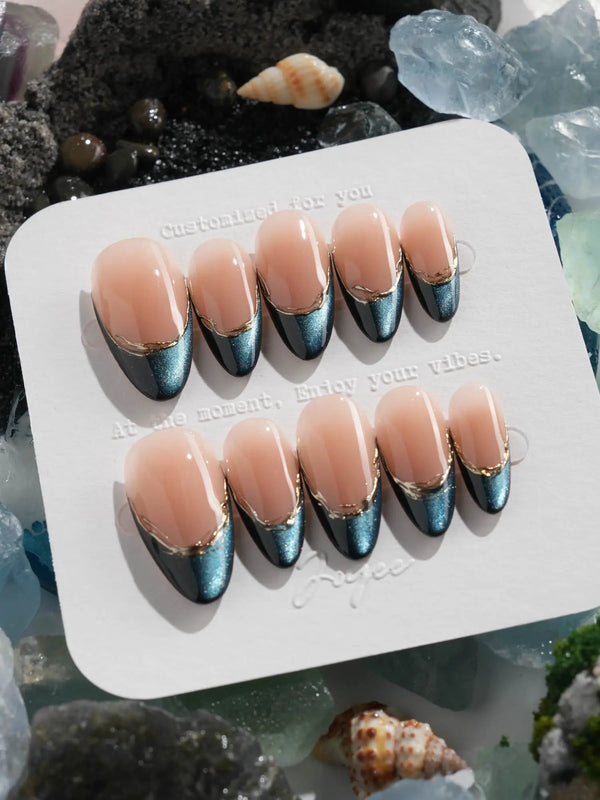 Almond-shaped press-ons with magnetic blue tips and nude base	