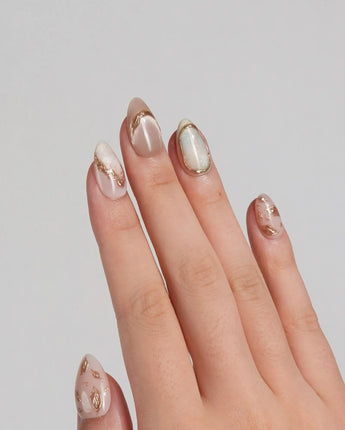 Earthy glow press-on nails with earthy beige-peach base and delicate gold foil accents