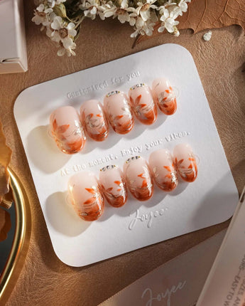 Amber Maple press-on nails with glossy amber French tips and delicate maple leaf accents