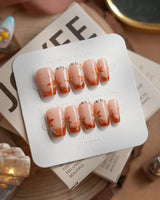 Amber Maple press-on nails in short coffin shape — orange french tips gold outline maple leaves
