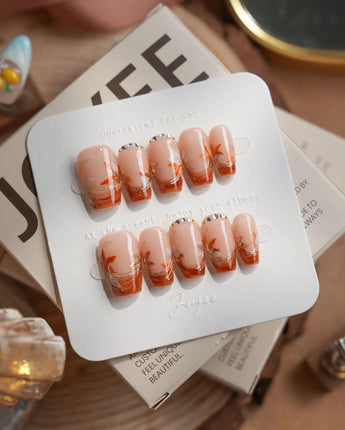 Amber Maple short coffin press-on nails with orange French tips and gold maple leaves