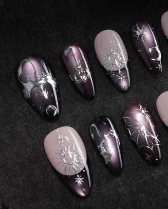 Arcana press on nails with sculpted silver sun, moon, star and key charms and a silver wing on plum and black cat eye with crystals - image 1