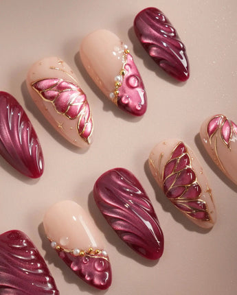 Close-up of Velvet Flow press-on nails with red cat-eye texture and outlined butterfly wings
