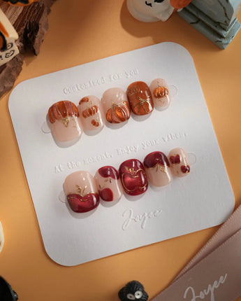 Autumn Bounty press-on nails with orange pumpkin, red apple and gold outlined nude nails