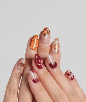 Autumn Bounty press-on nails with pumpkin and apple nail art on a soft nude base