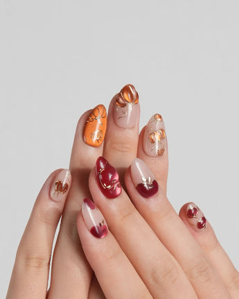 Autumn Bounty press-on nails with pumpkin and apple nail art on a soft nude base