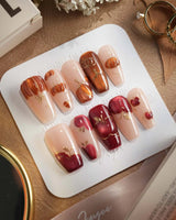 Autumn Bounty press-on nails with glossy nude base, pumpkin art and red apple details