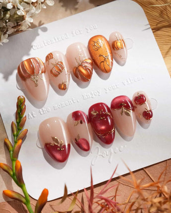 Close-up of Autumn Bounty press-on nails with 3D pumpkins, red apples and gold outlines