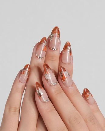 Amber Maple press-on nails with autumn maple leaf accents and gold outlined orange tips