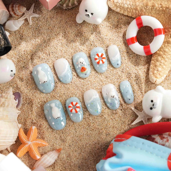 Baby Seals short oval nails with light blue ocean waves, 3D seal pups, and lifebuoys