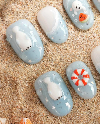 Baby Seals glossy sea-themed nails with 3D seals and soft ocean blue base