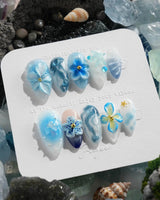 Bali Blue tropical garden nails with sculpted blue florals, waves, and dewy jelly gloss