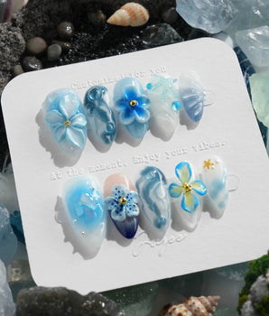 Bali Blue tropical garden nails with sculpted blue florals, waves, and dewy jelly gloss