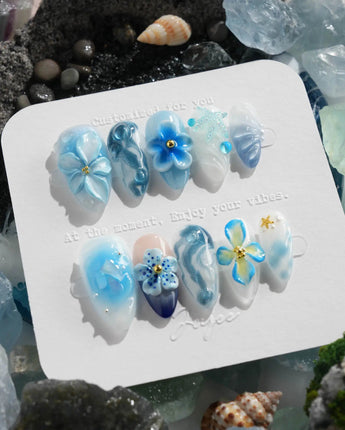 Bali Blue tropical garden nails with sculpted blue florals, waves, and dewy jelly gloss