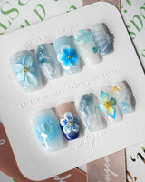 Bali Blue short coffin nails with ocean blue jelly gloss and sculpted floral accents