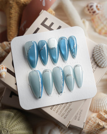 Banff Blue medium stiletto nails with glacier-blue cat-eye shine and chrome outline