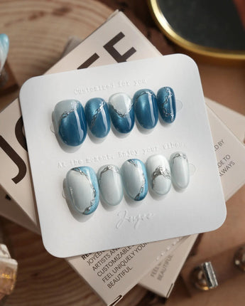Banff Blue short oval nails with icy blue magnetic gel and silver chrome lines