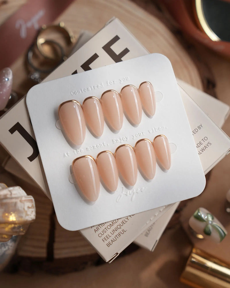 Nude nail designs on short almond press-on nails in minimalist champagne gold style by Joyee Nails