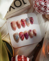 Baroque Palette press-on nails with glossy red-blue marble swirls and gold trim details