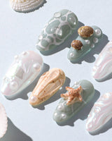 Mauritius Escape beach nails with iridescent white shimmer, shell accents, and pearl drops