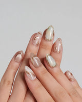 Earthy glow press-on nails with peach nude gel, gold foil leaf details and glossy finish