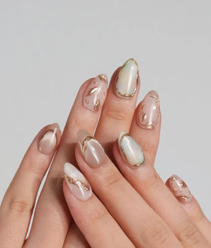 Earthy glow press-on nails with peach nude gel, gold foil leaf details and glossy finish